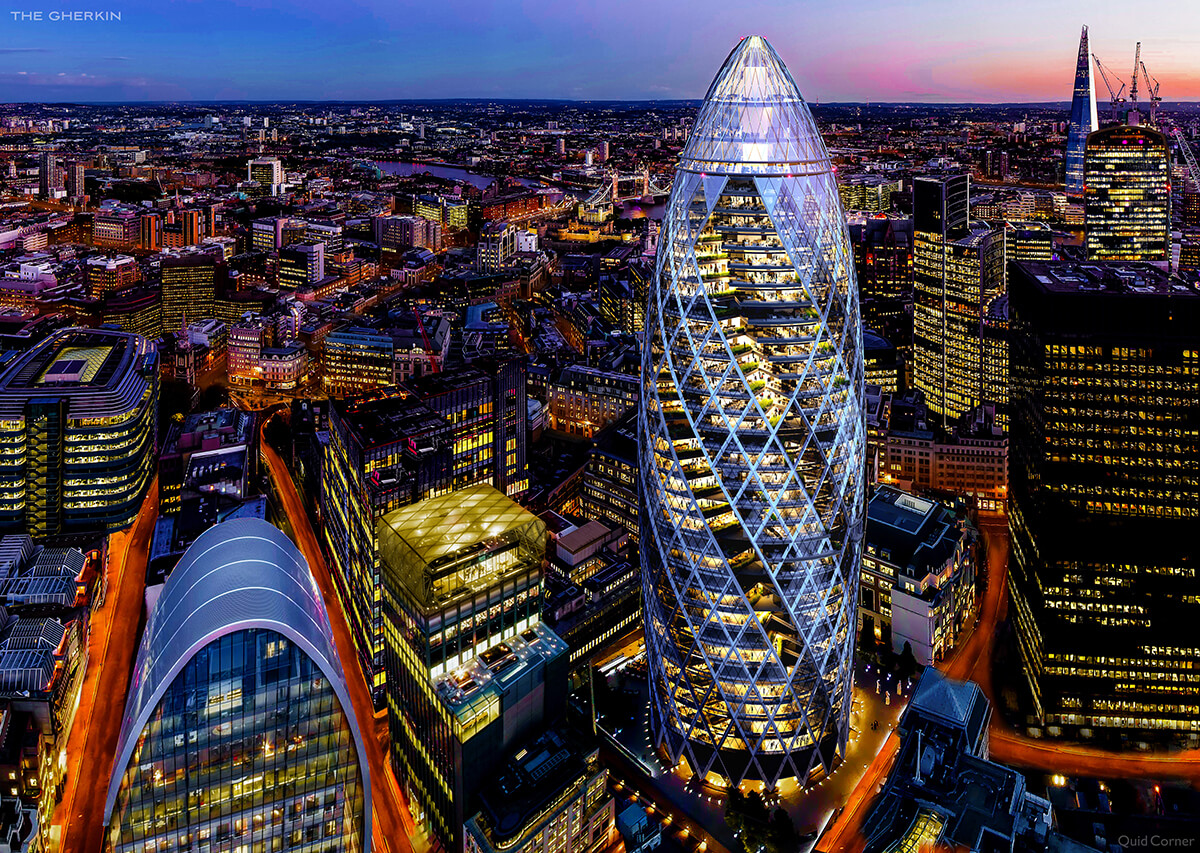 Nighttime aerial view of the gherkin building in London, a tall cylindrical building