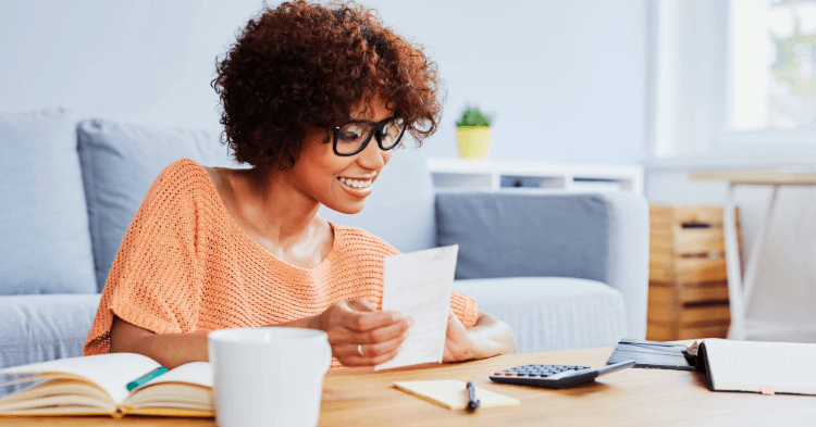 Woman sitting at coffee table reviewing finances