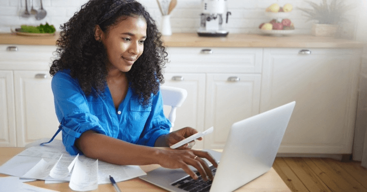 Woman at her table on a laptop working on finances