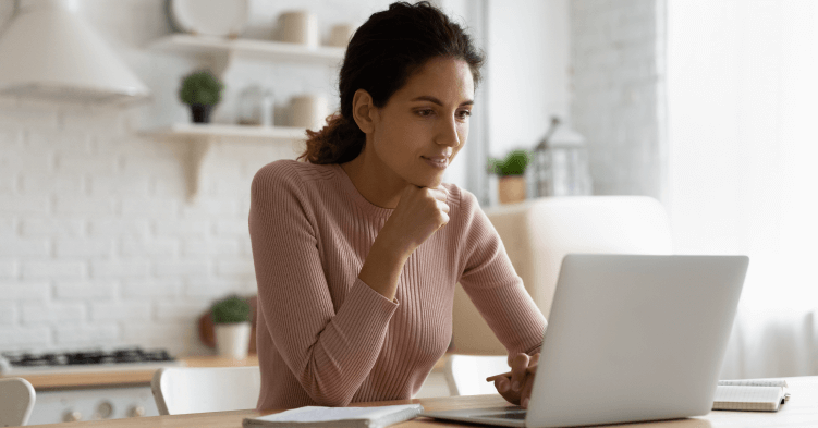 Woman looking at laptop, seated.