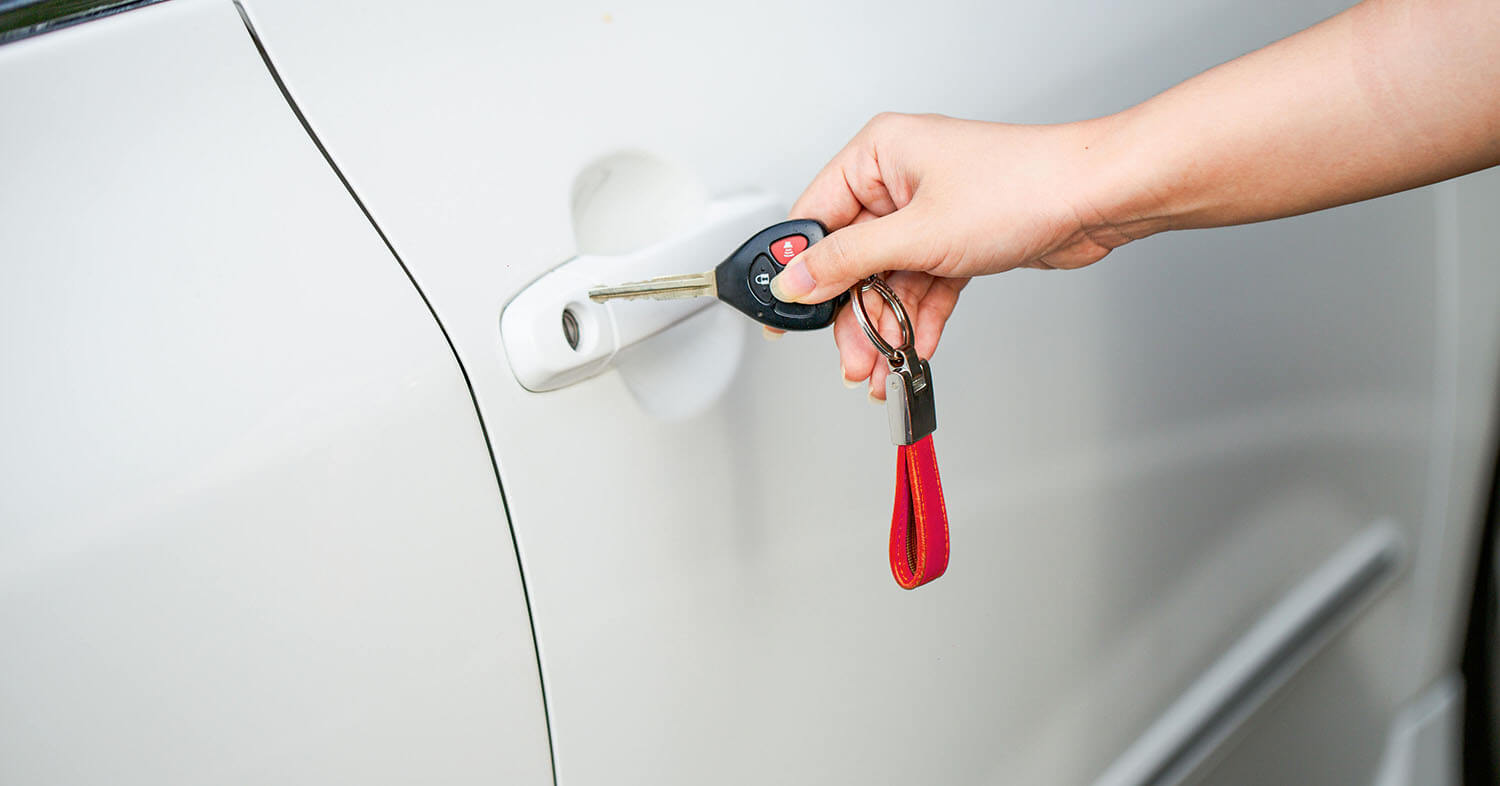 Person placing key into car door