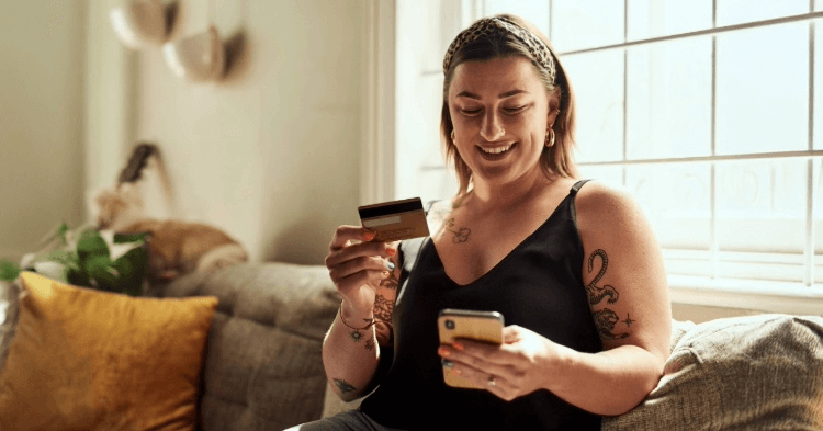 Woman on her couch with a revolving credit card and phone